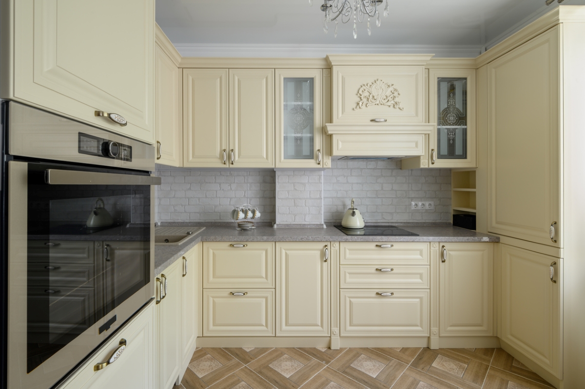 Cream colored kitchen with faux brick wall finish.
