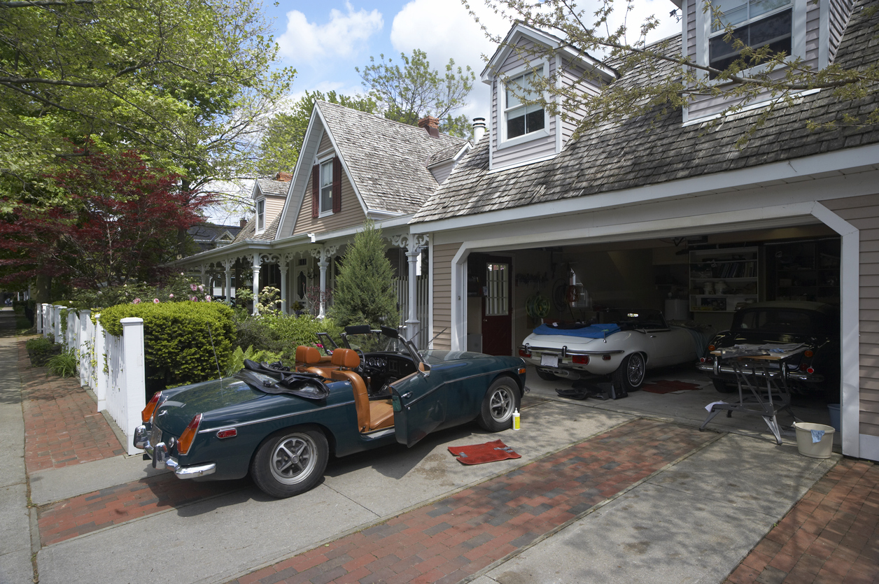 Tan home with garage containing three vintage cars.