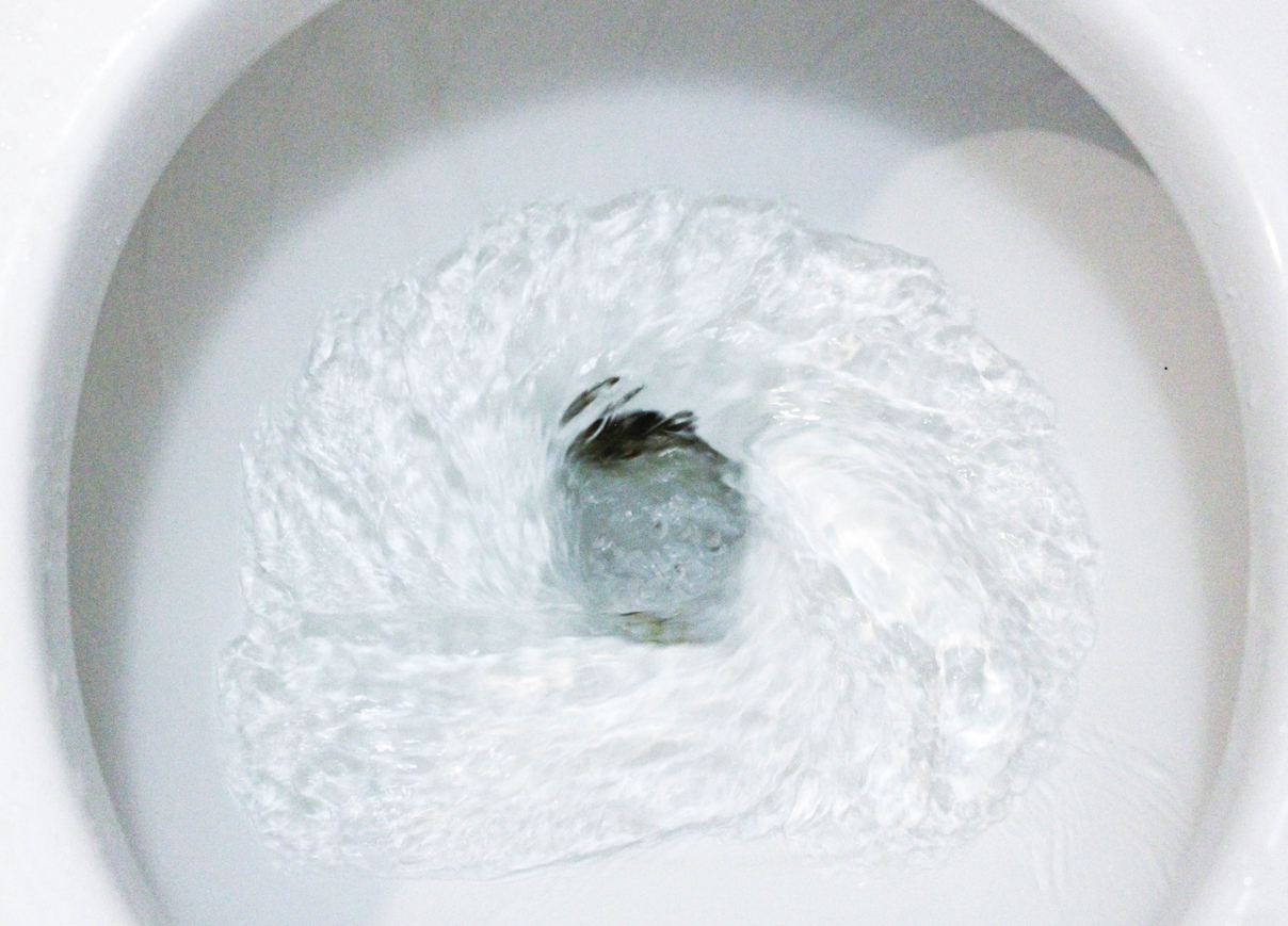 A toilet bowl being flushed.