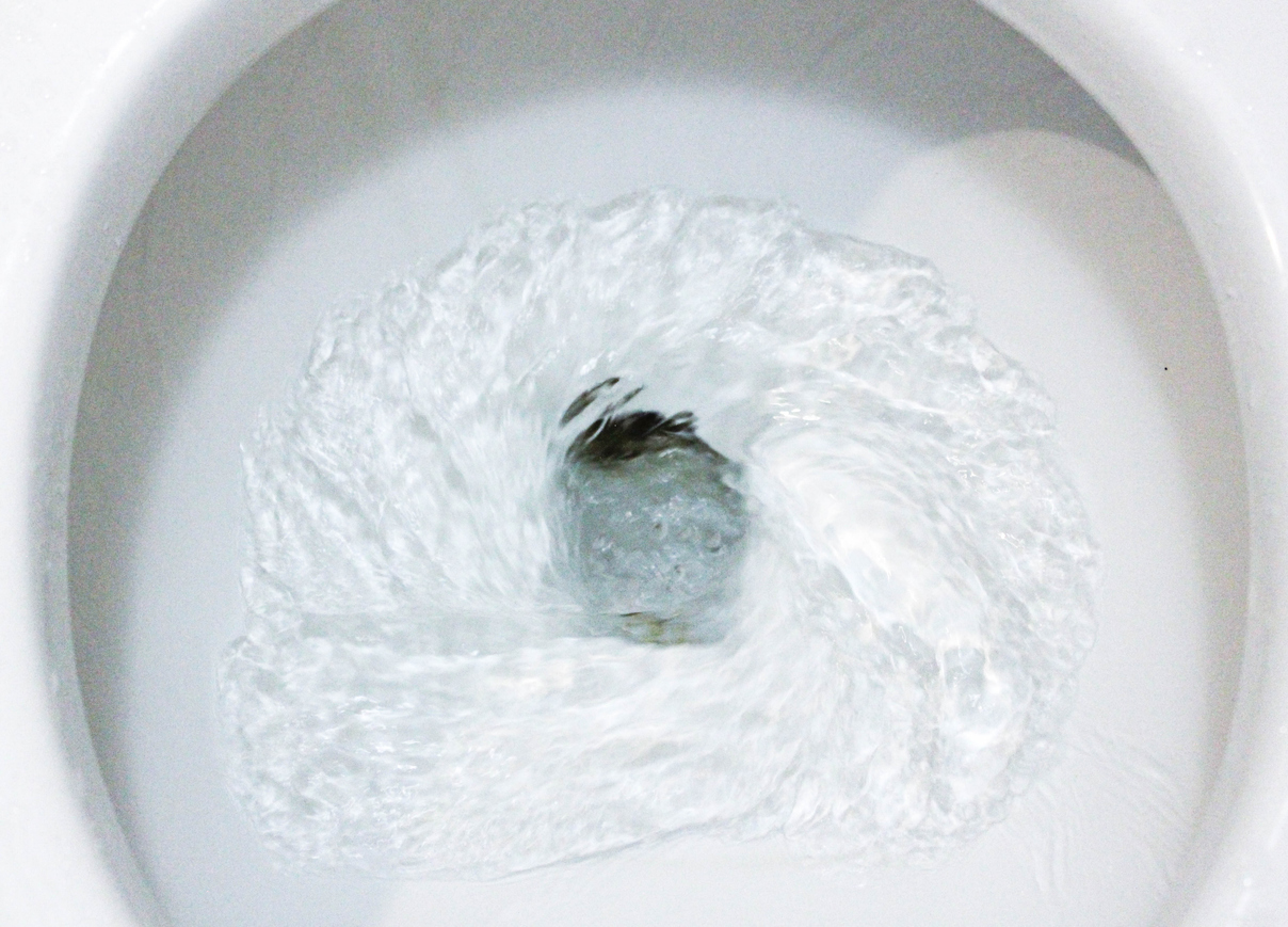 A toilet bowl being flushed.