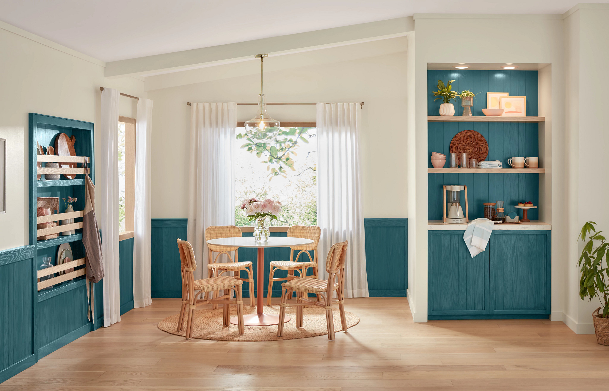 A natural colored breakfast nook is near teal colored kitchen cabinets