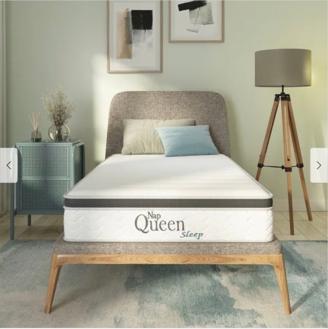 A Nap Queen brand mattress is resting on a wood midcentury bed frame in a modern bedroom.
