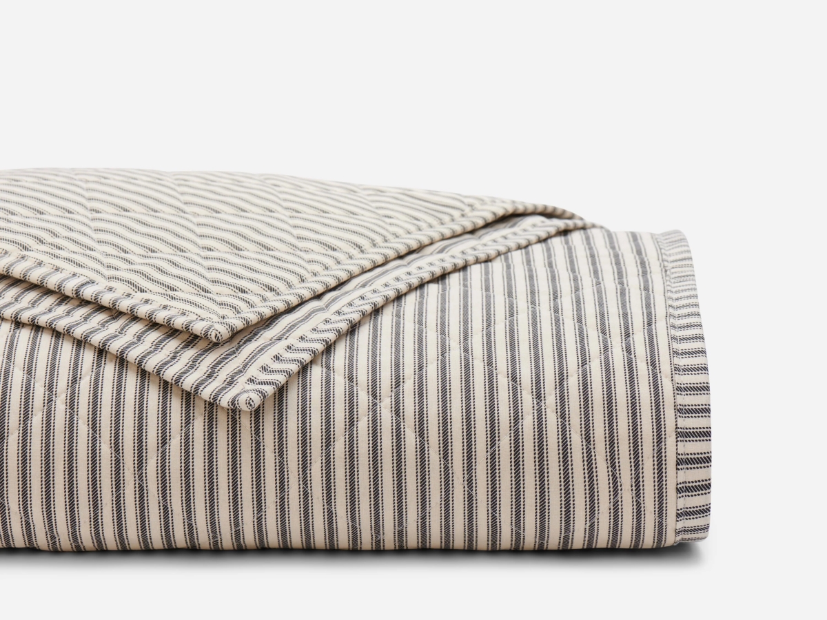 Rolled striped quilted blanket.