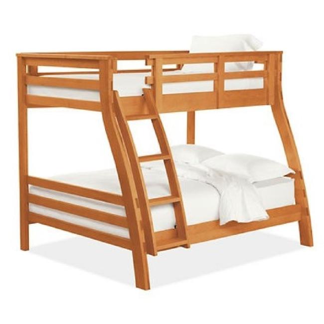 A cherry wood bunk bed is made up with white bedding.