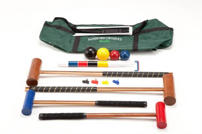 A croquet set is arranged around a green storage bag for the game.