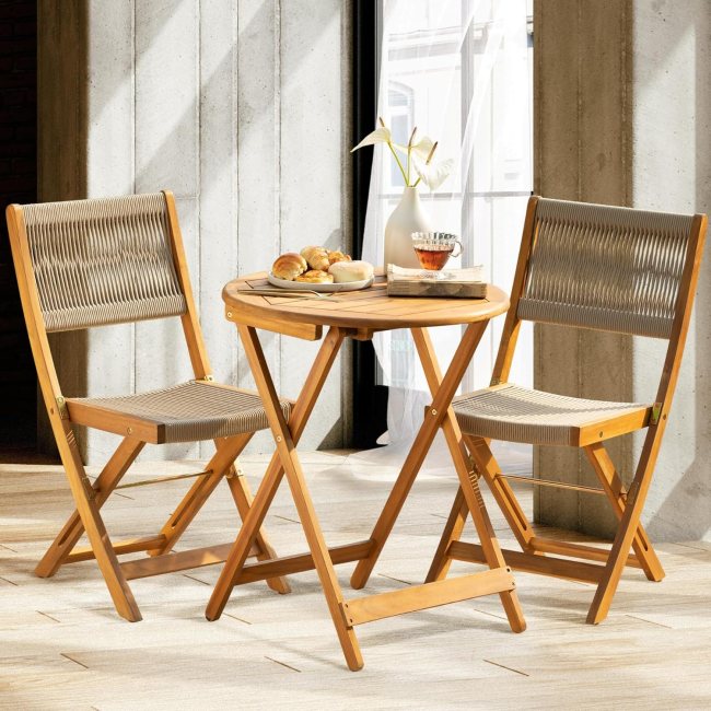 A wood bistro set with a round table sits on a patio in the sun.