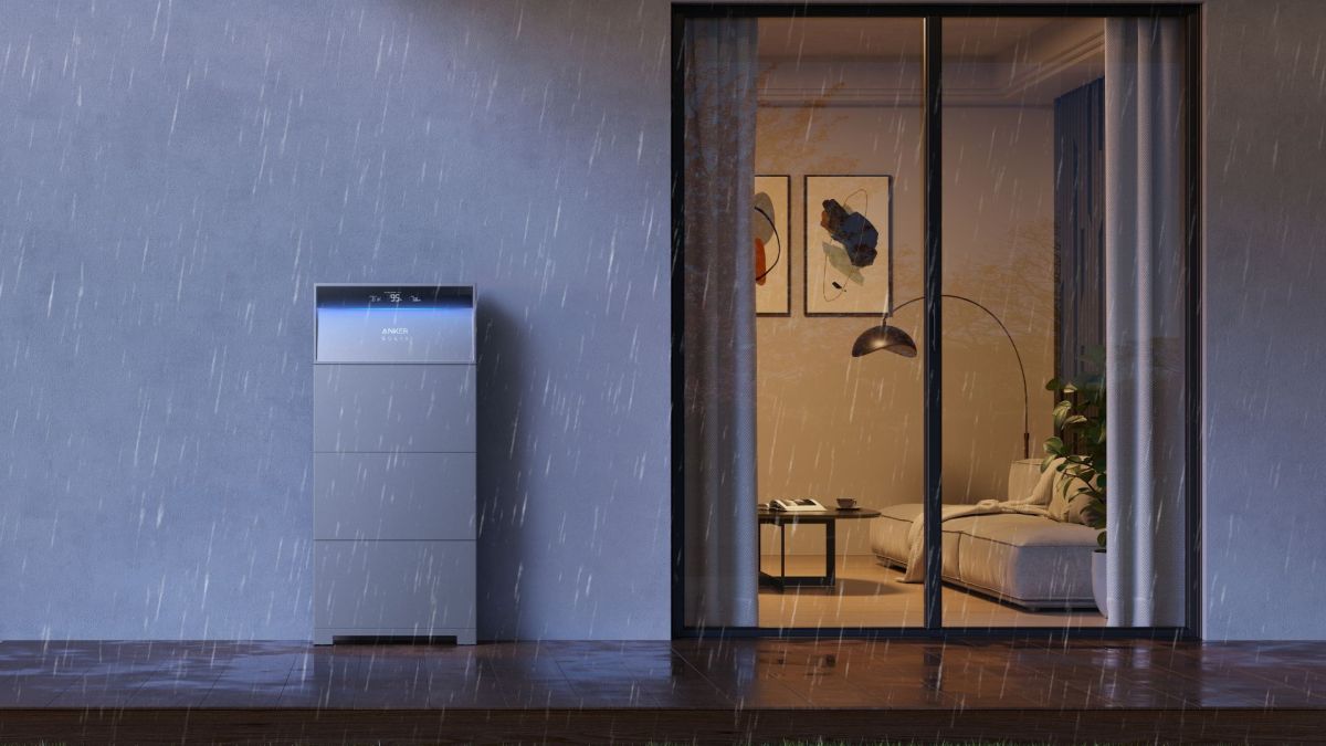 Anker's Solix X1 outside a house with lights on, keeping it powered during a rain storm