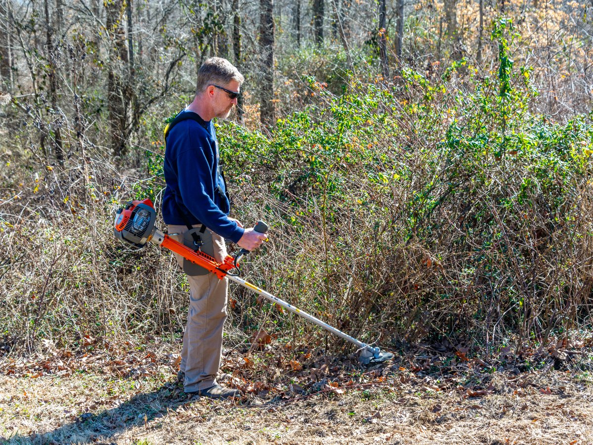 a man using one of the models of the Best Brush Cutter