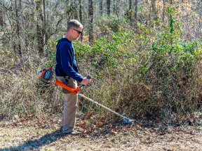 a man using one of the models of the Best Brush Cutter