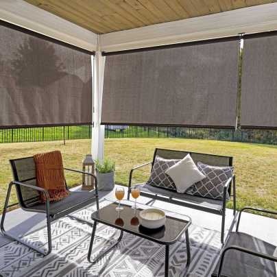 The Coolaroo Outdoor Roller Shade installed along the sides of an outdoor seating area.