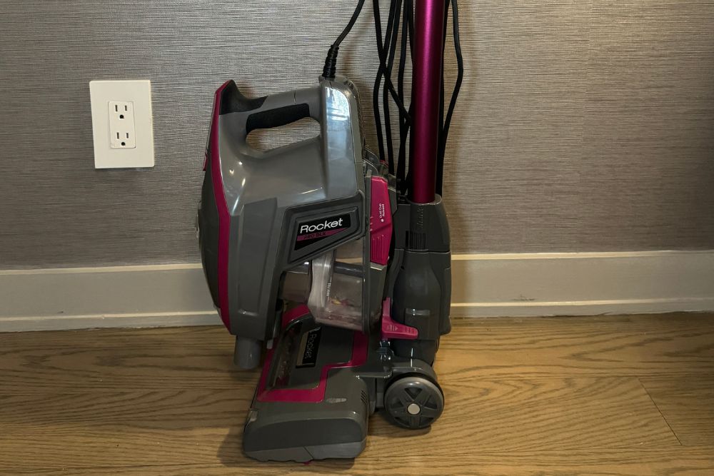 The Shark Rocket Pro DLX Corded Stick Vacuum next to an apartment wall during testing.