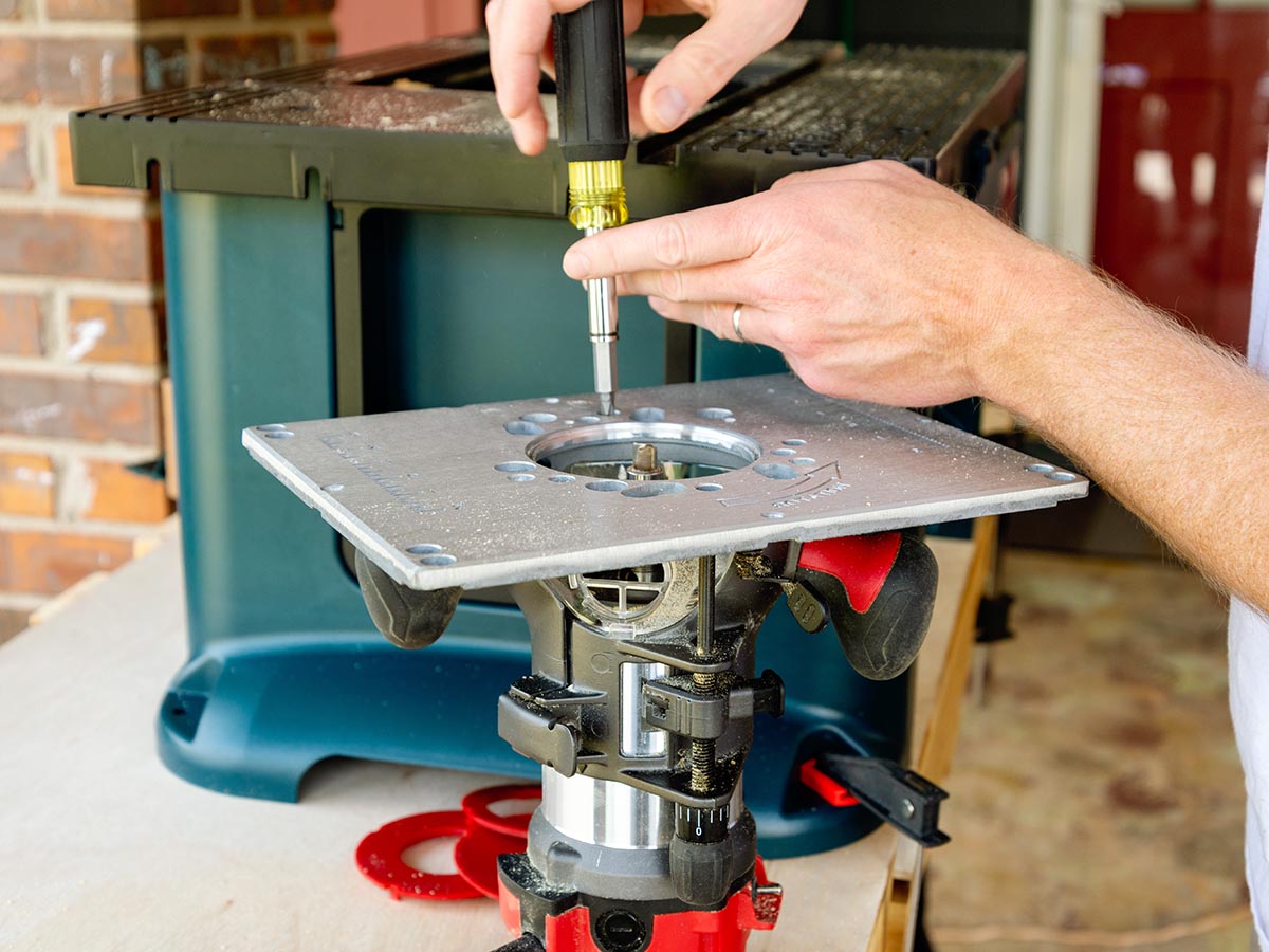 A person adjusting the router table on the Bosch Benchtop RA1181 during testing.