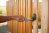 A close up of a hand painting a wooden fence.
