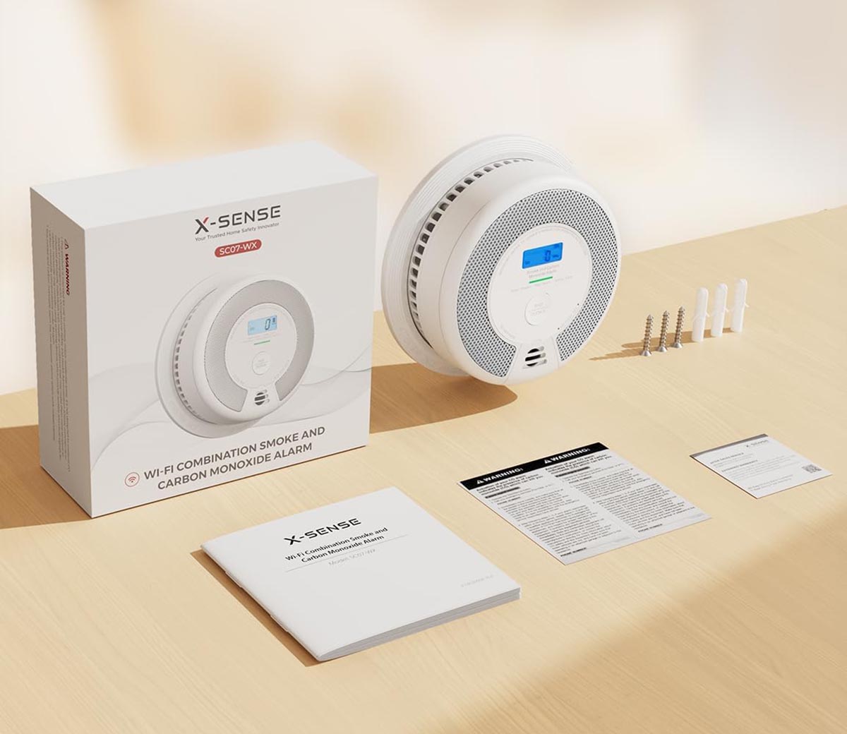 A close up of an X-sense smoke alarm and its components and box laid out on a table. 
