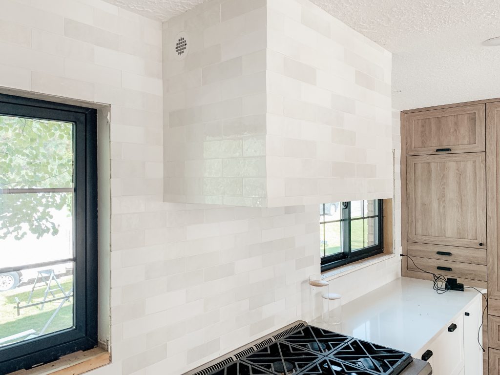 A white tiled range hood in a white farmhouse-themed kitchen.