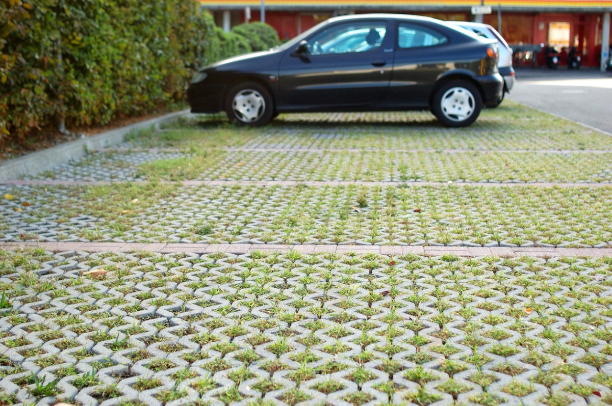A close up of permeable pavers with a car in the background.