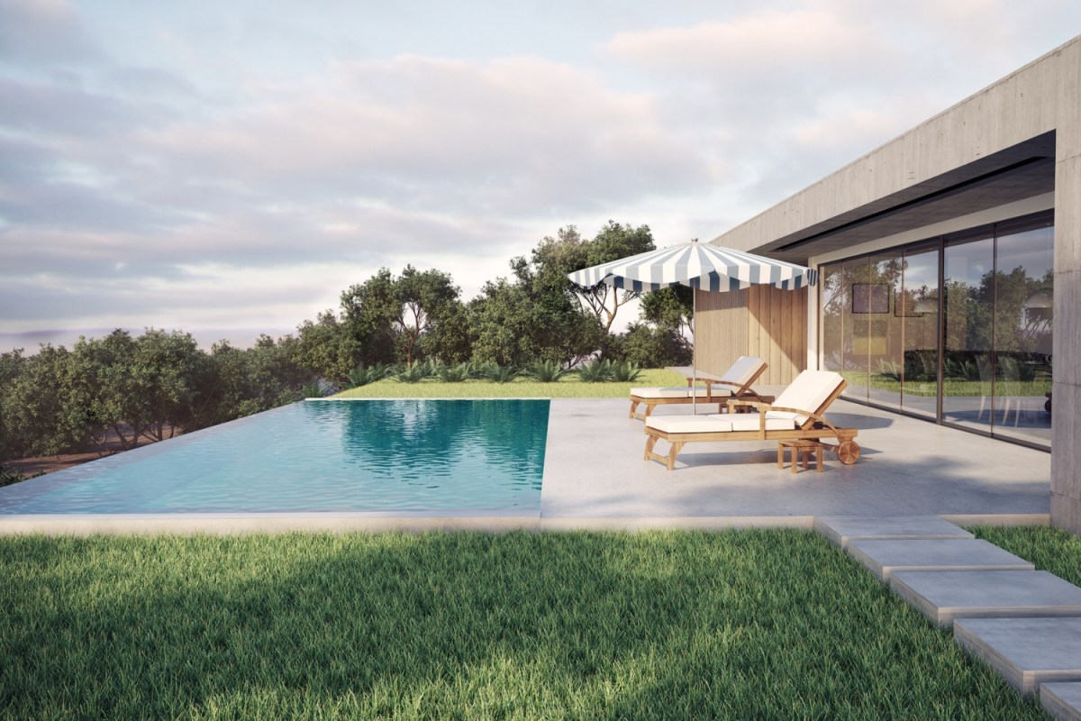 A view of a pool, two lounge chairs, and an umbrella by a beautiful modern house. 