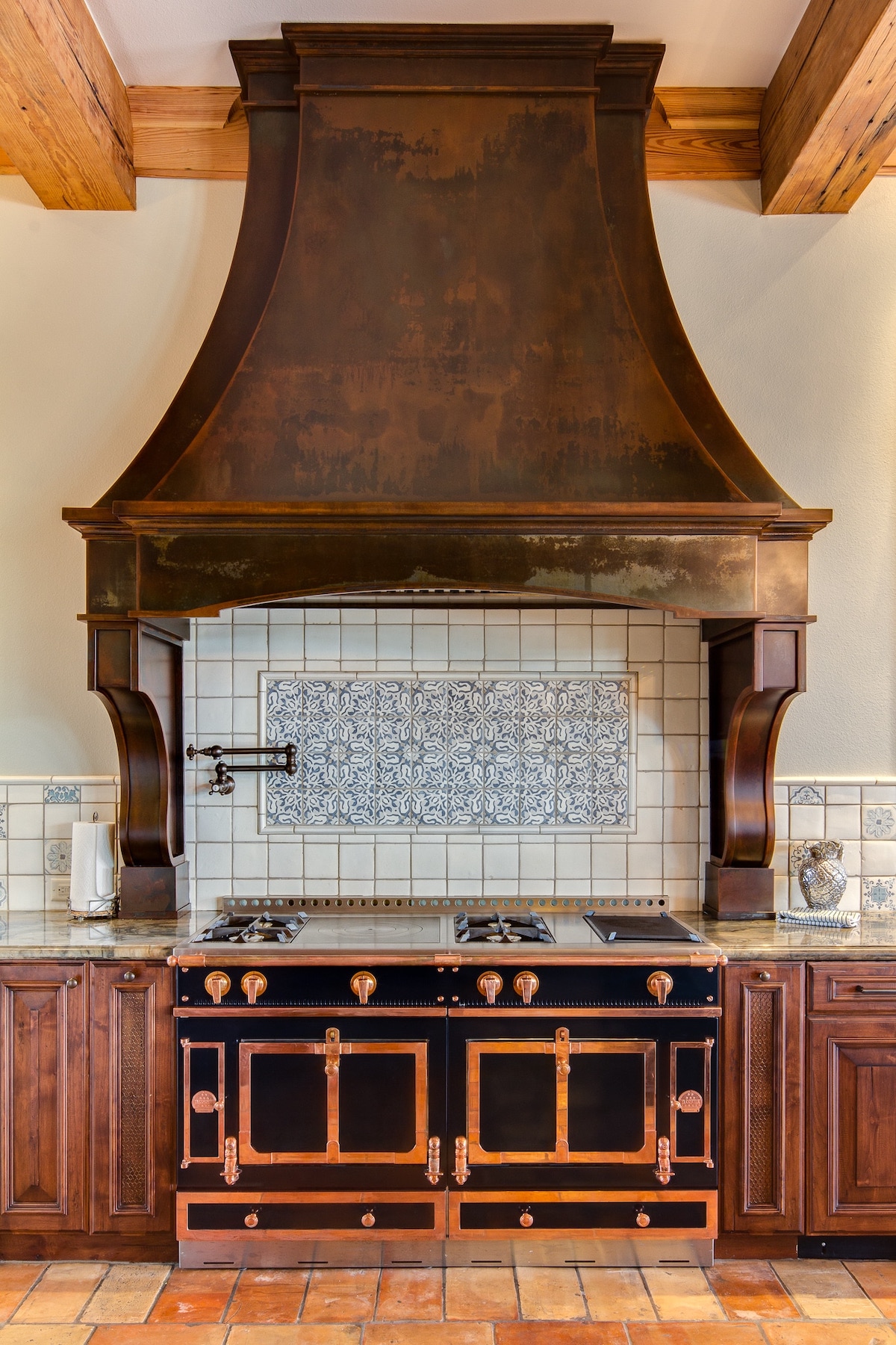 A rustic, oversized range hood in a medieval European–style kitchen.