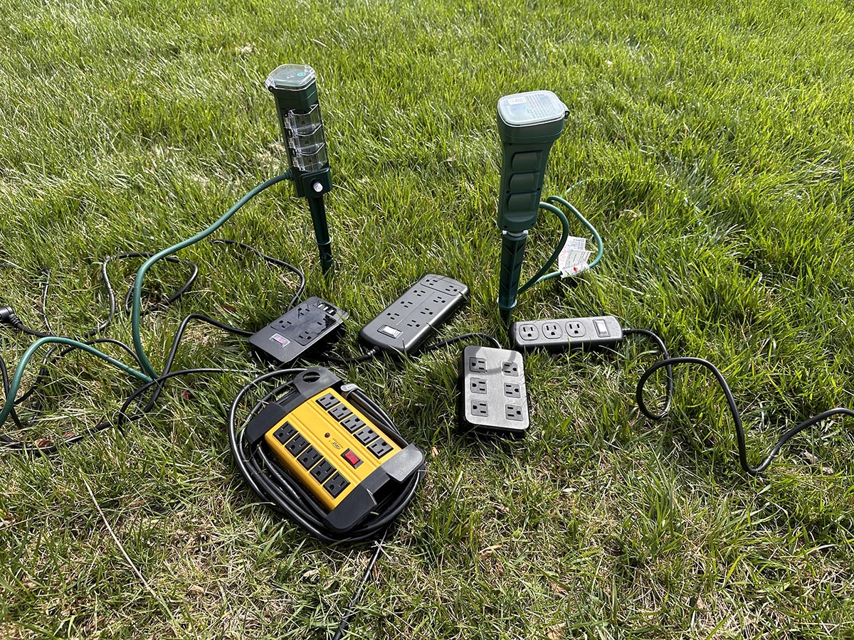 A group of the best outdoor power strips in a yard before testing.