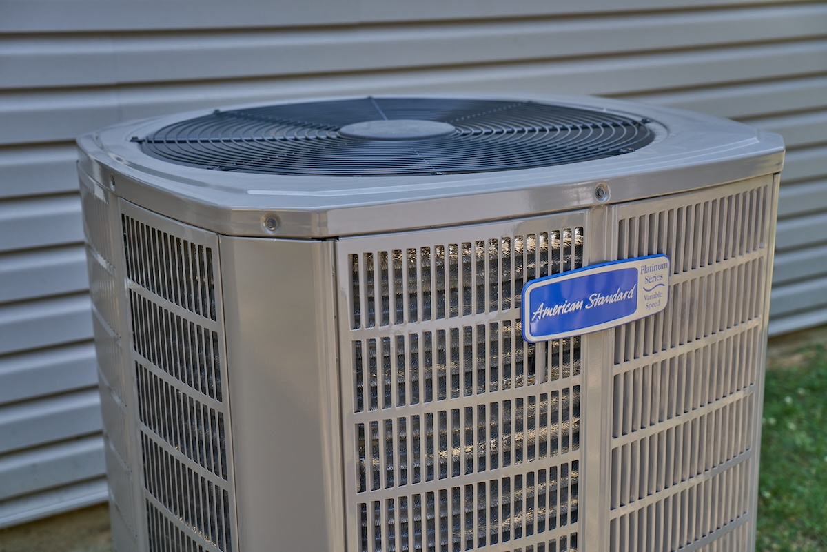 An American Standard heat pump unit outside of a residential home.