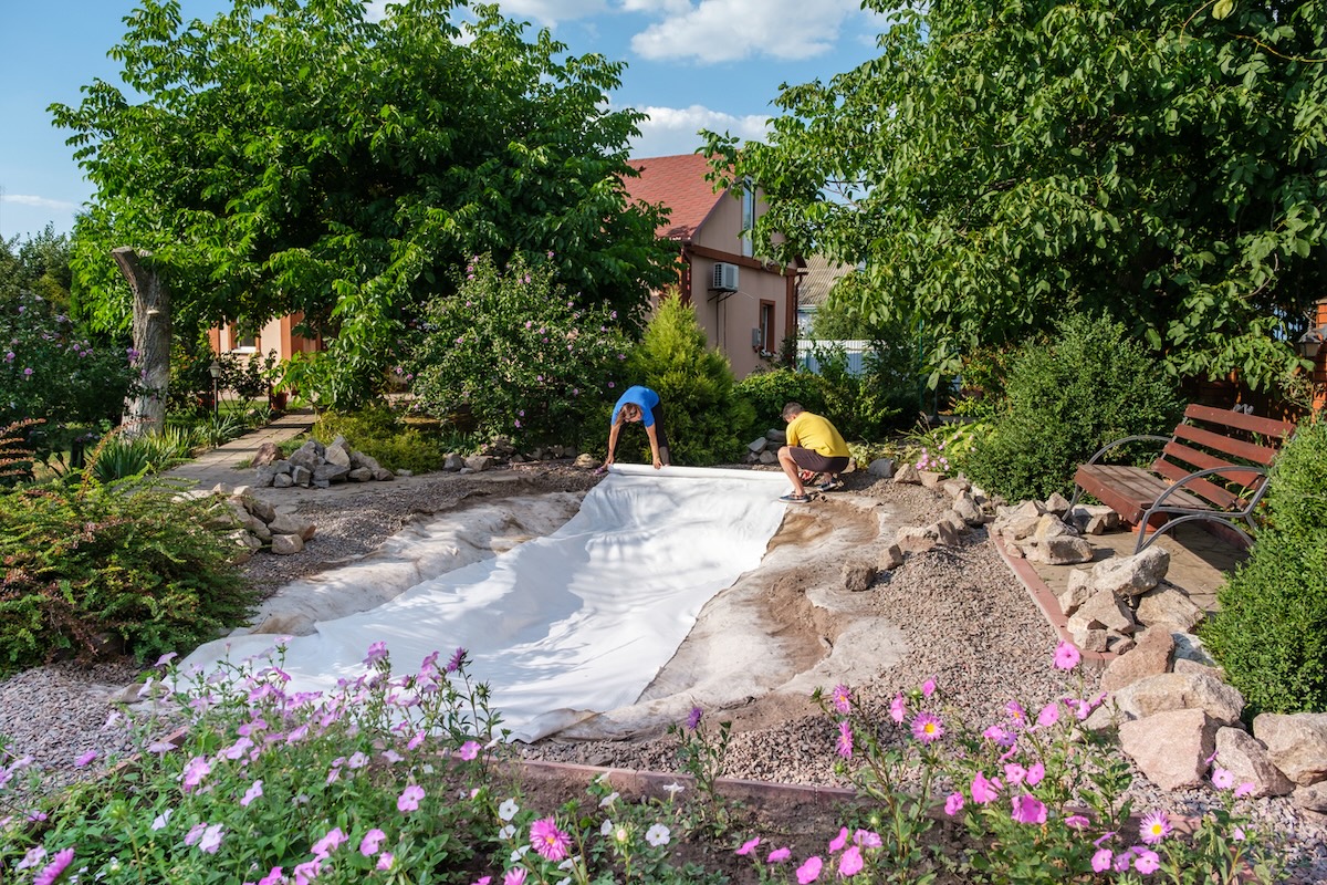 Installing a natural pool in a home's backyard.