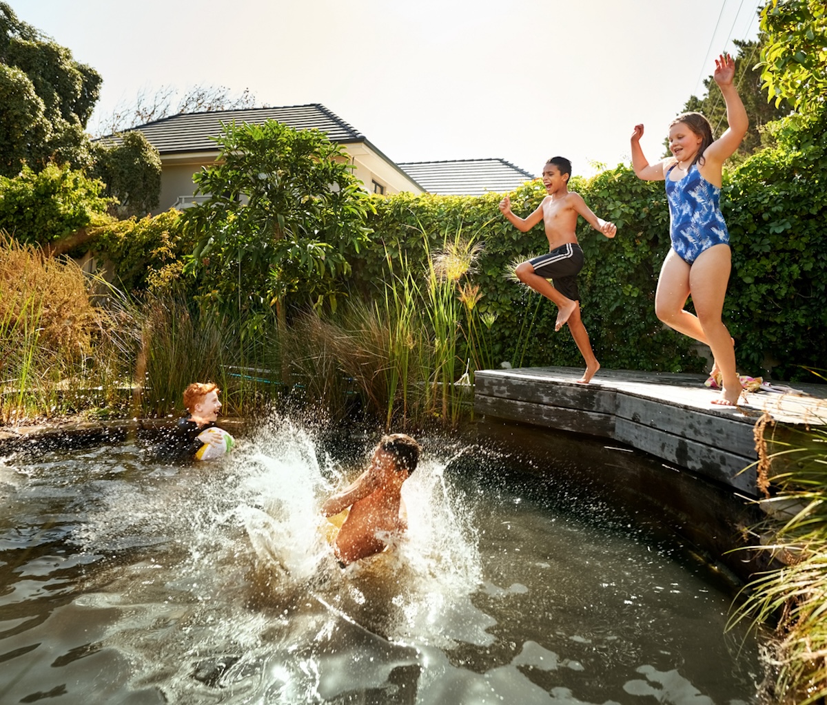 Children jumping into natural pool.