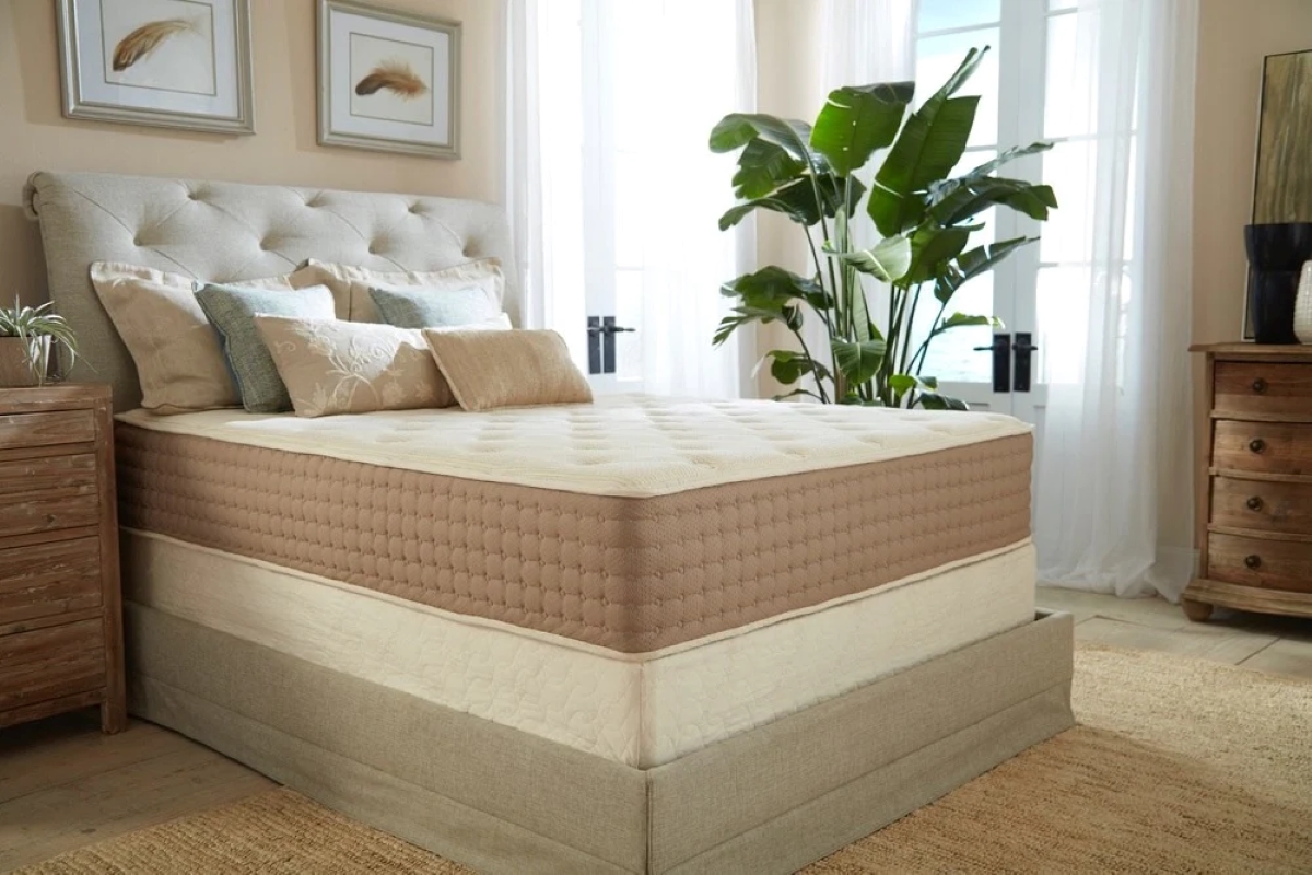 Large beige bed with new mattress in bedroom.