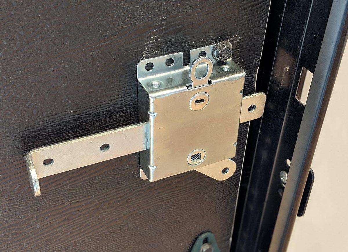 A retrofit garage door side lock product installed on a residential garage door.