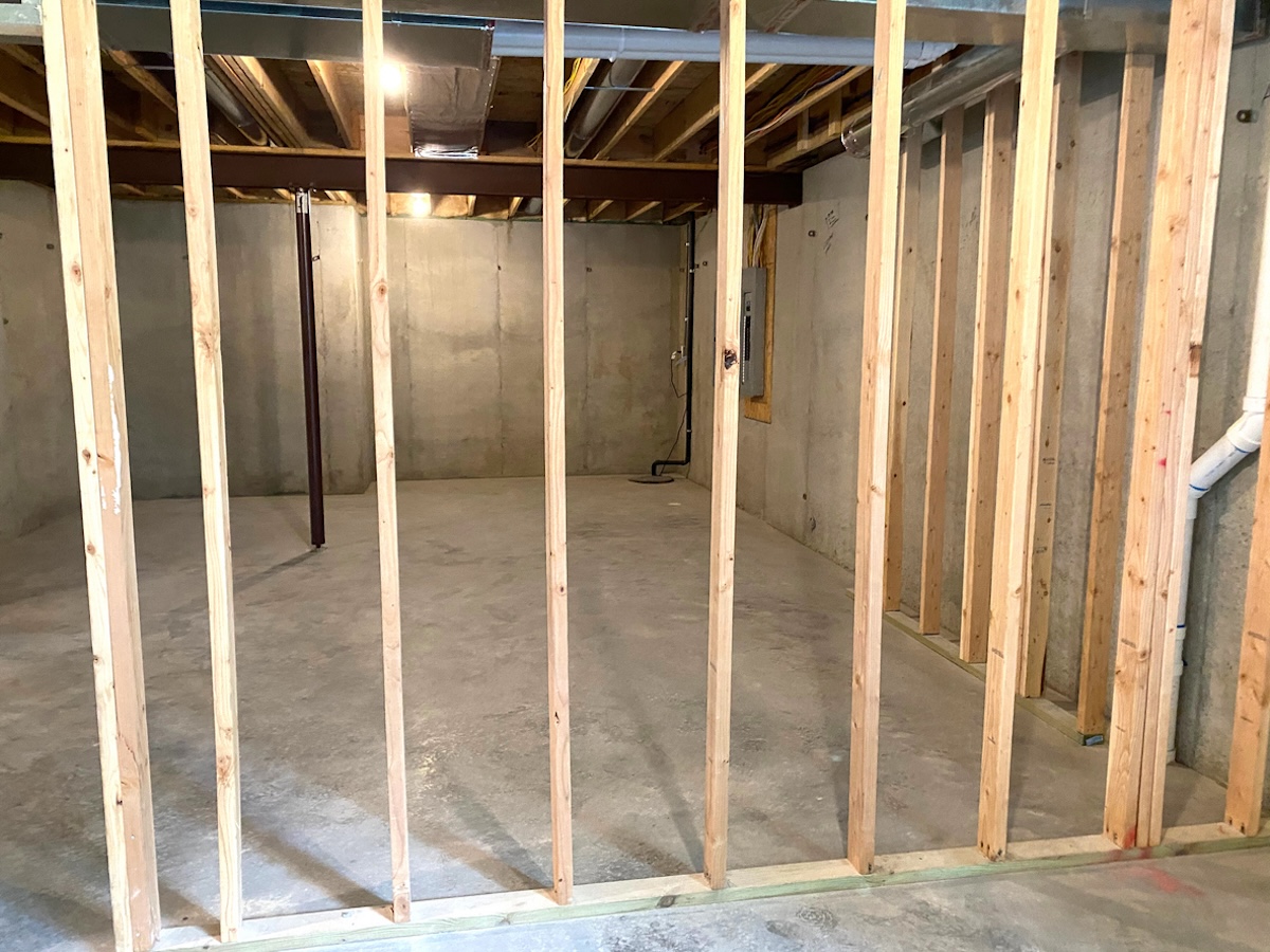 An unfinished basement with a stud wall built.