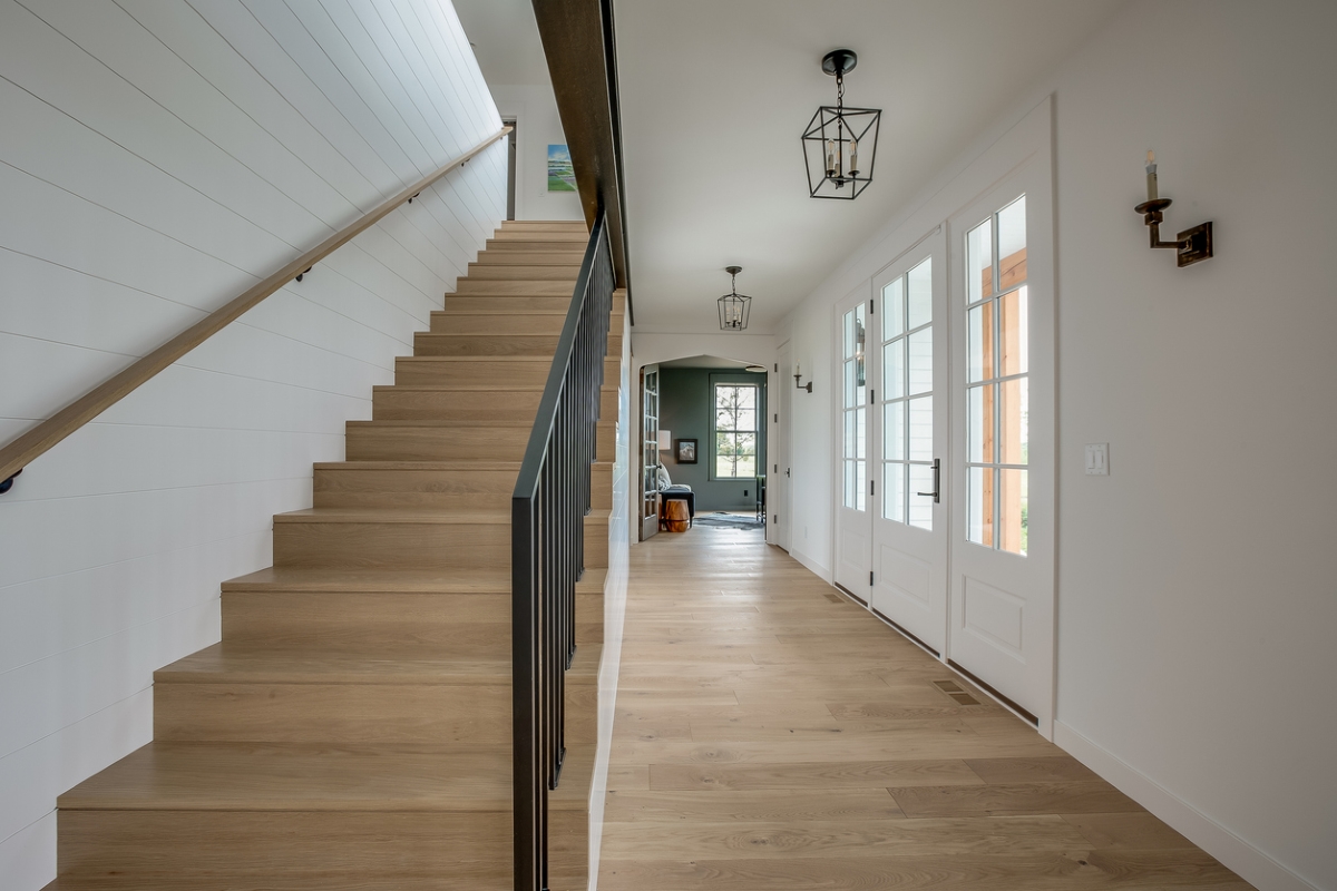 A straight staiwell leading to the second floor of a modern farmhouse-style home.