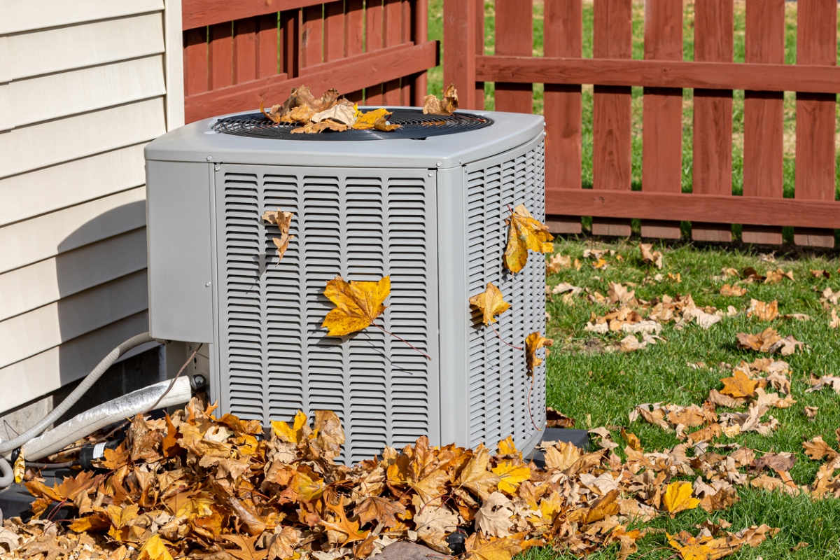 Fallen leaves collecting around an air conditioner unit.