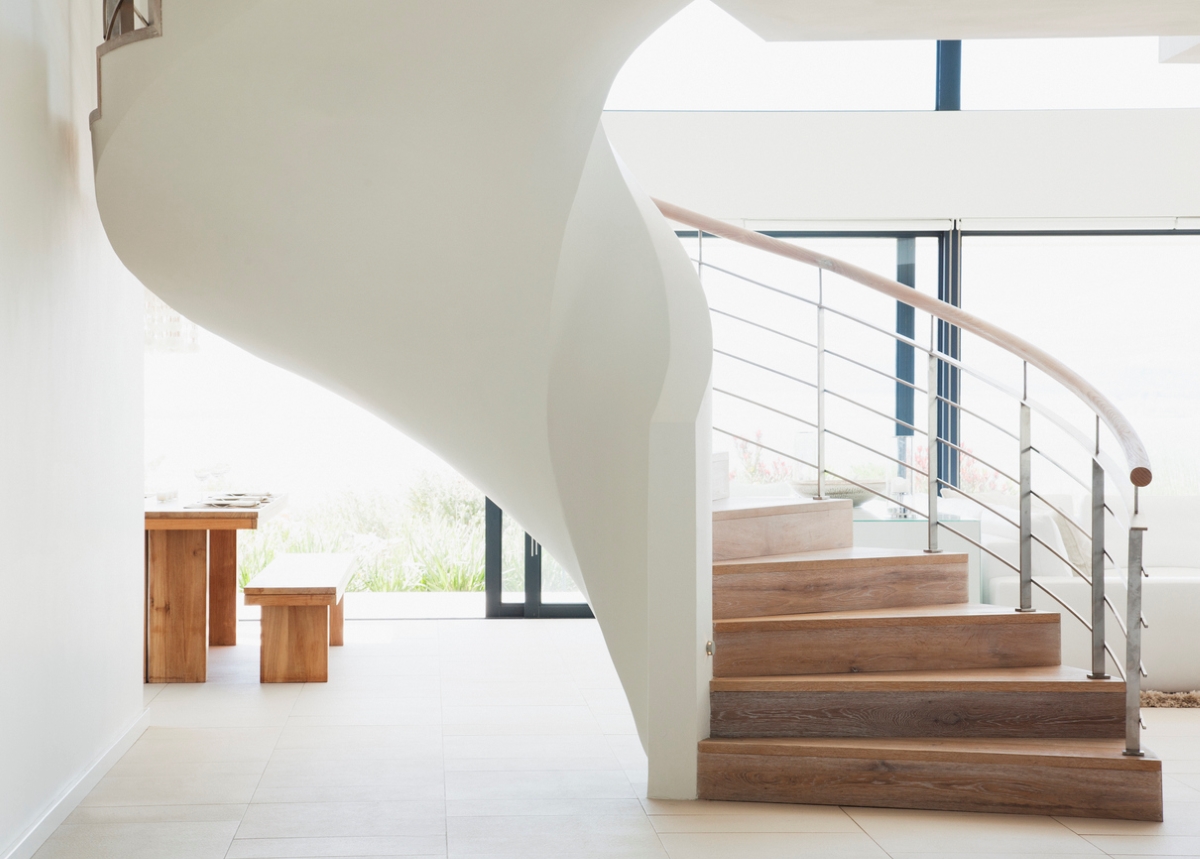 A large curved staircase in a modern open-plan home.
