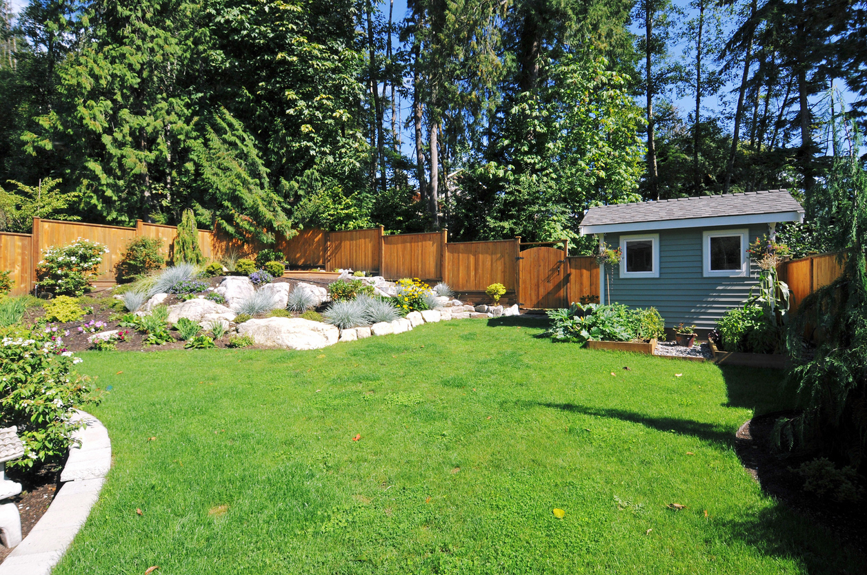 A manicured back yard features two rock gardens.
