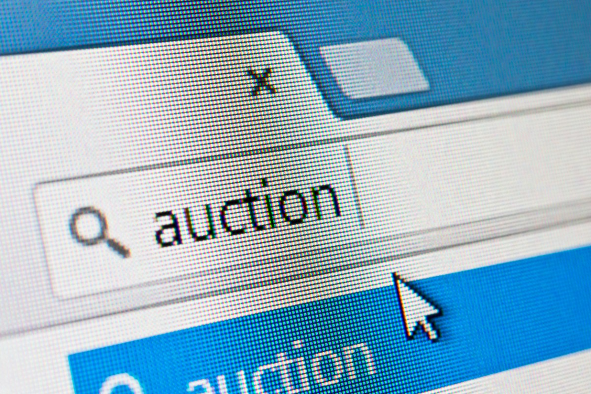 A cursor chooses the word auction on a screen.