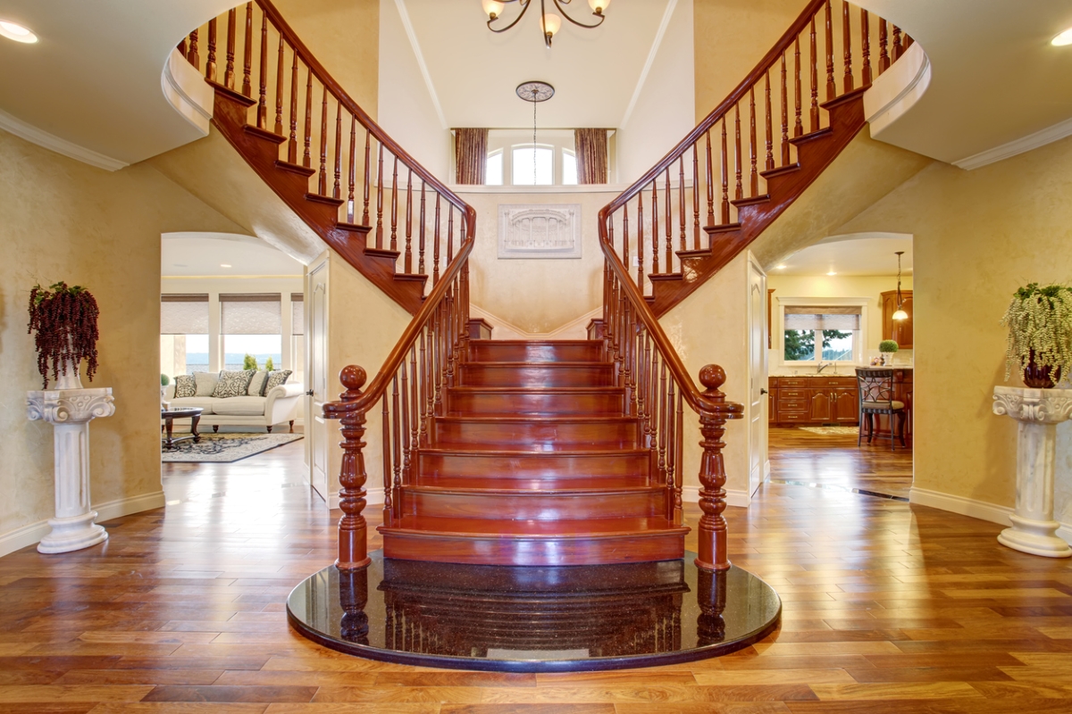 A large bifurcated wooden staircase leading to either side of the second floor of a traditional house.