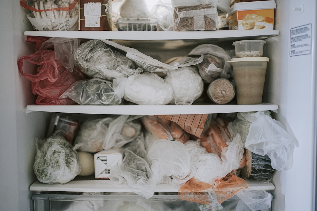 Overpacked freezer with food packages. 