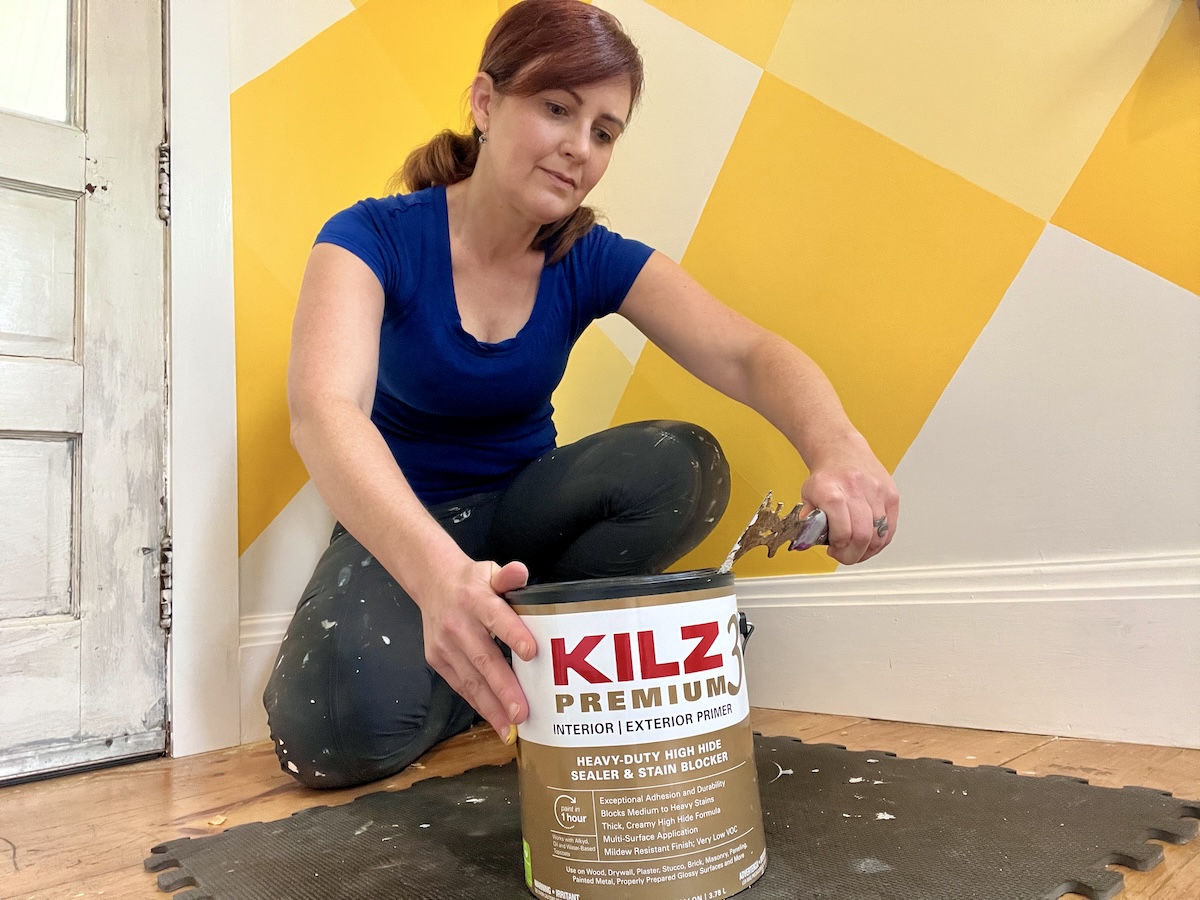 Theresa Clement opening a paint can with a multitool.