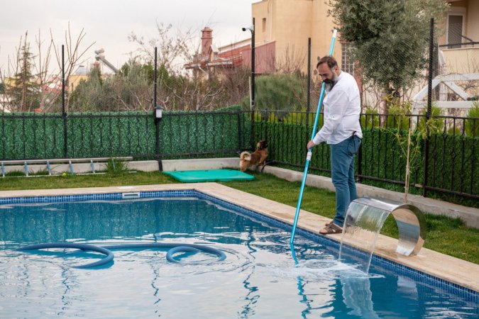 A man cleans a pool.