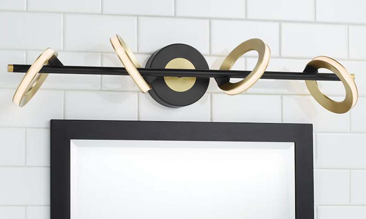 A contemporary black and brass bathroom vanity light hangs over a mirror.