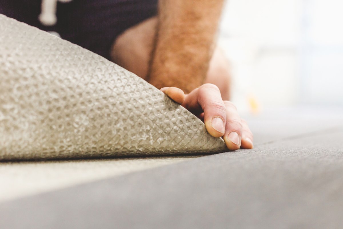 A close up of a person's hands fixing flooring. 