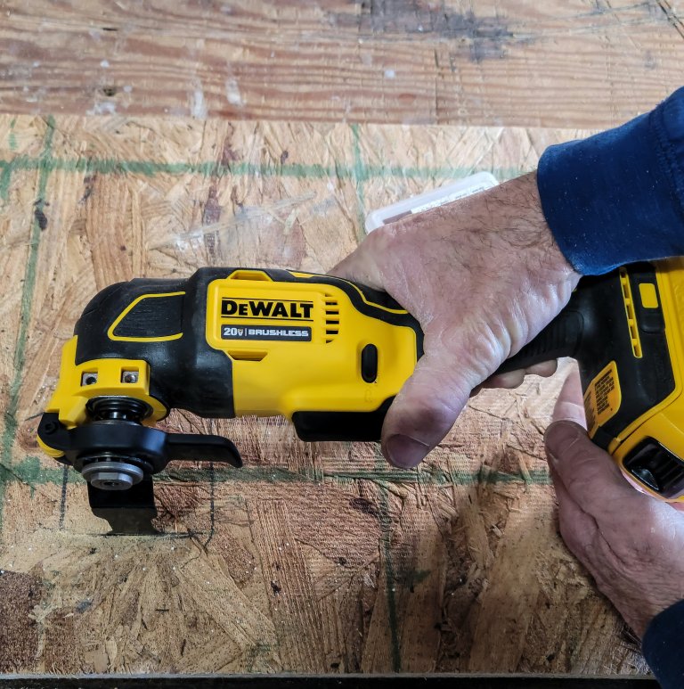 Person cutting wood with a dewalt oscillating tool