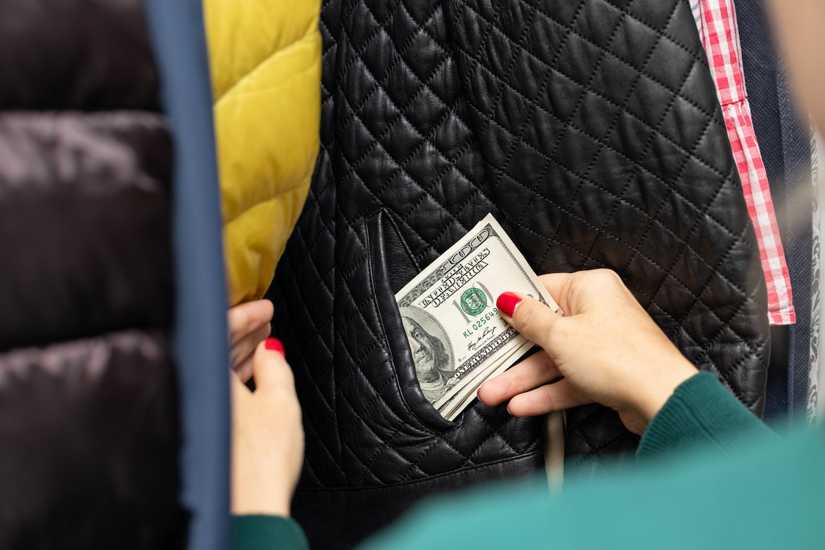 Hiding money in winter coat pockets while hanging in the closet.