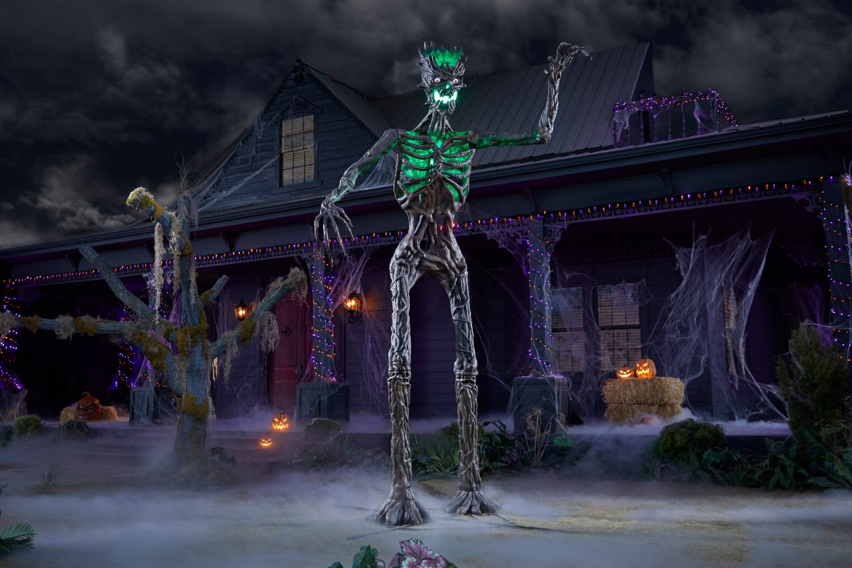 12.5-Foot Inferno Deadwood Skeleton from Home Depot's 2024 Halloween collection looming in front of a haunted house