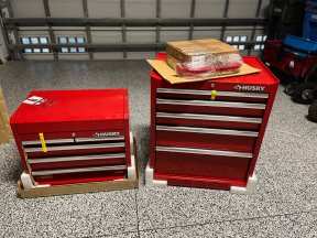 The Husky 10-Drawer Tool Chest and Cabinet Combo on a garage floor before assembly and testing.