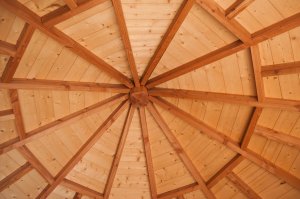 The interior of a gazebo is made of contrasting wood.