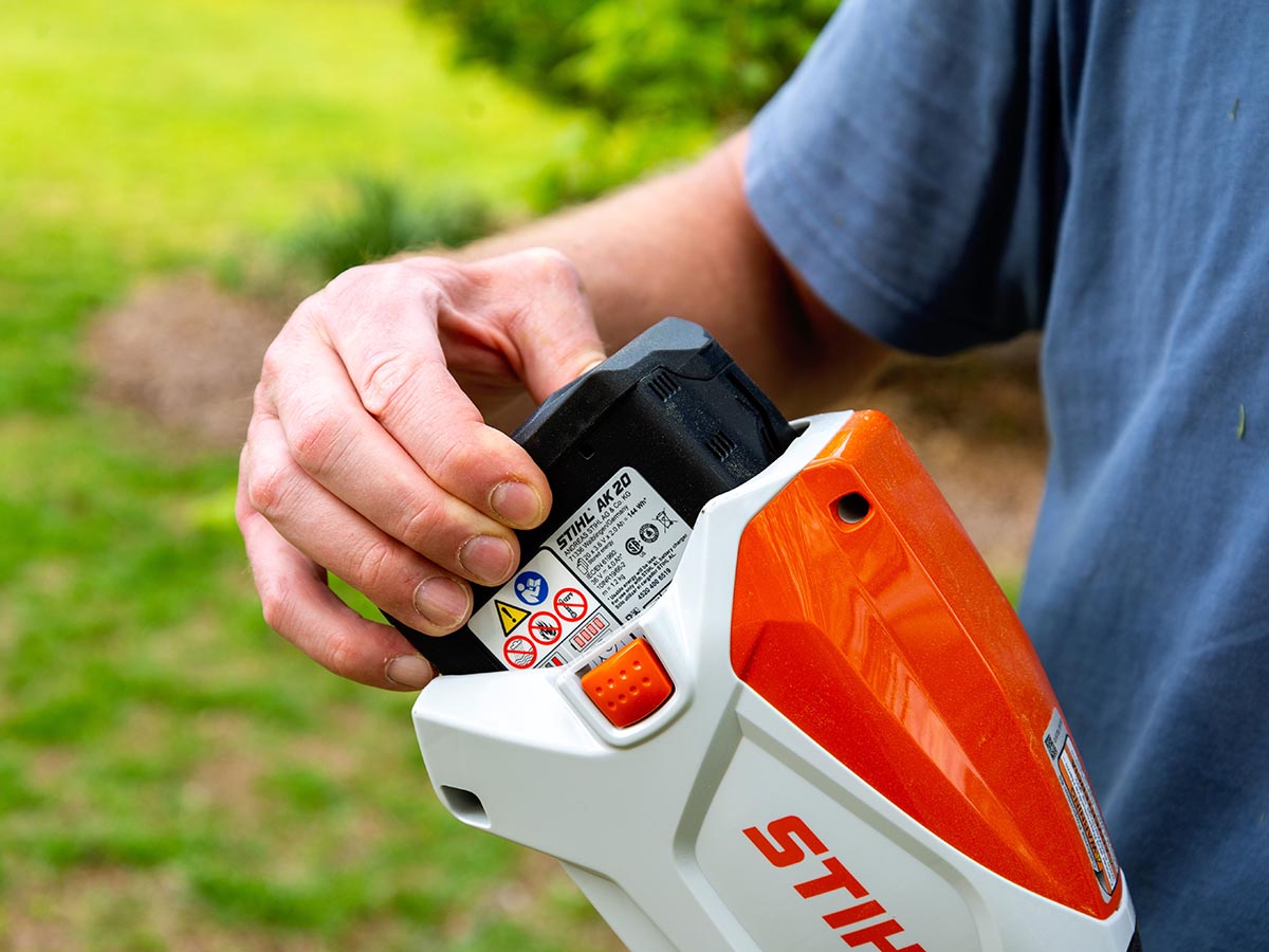 Person putting battery in Stihl FSA 80 R Trimmer