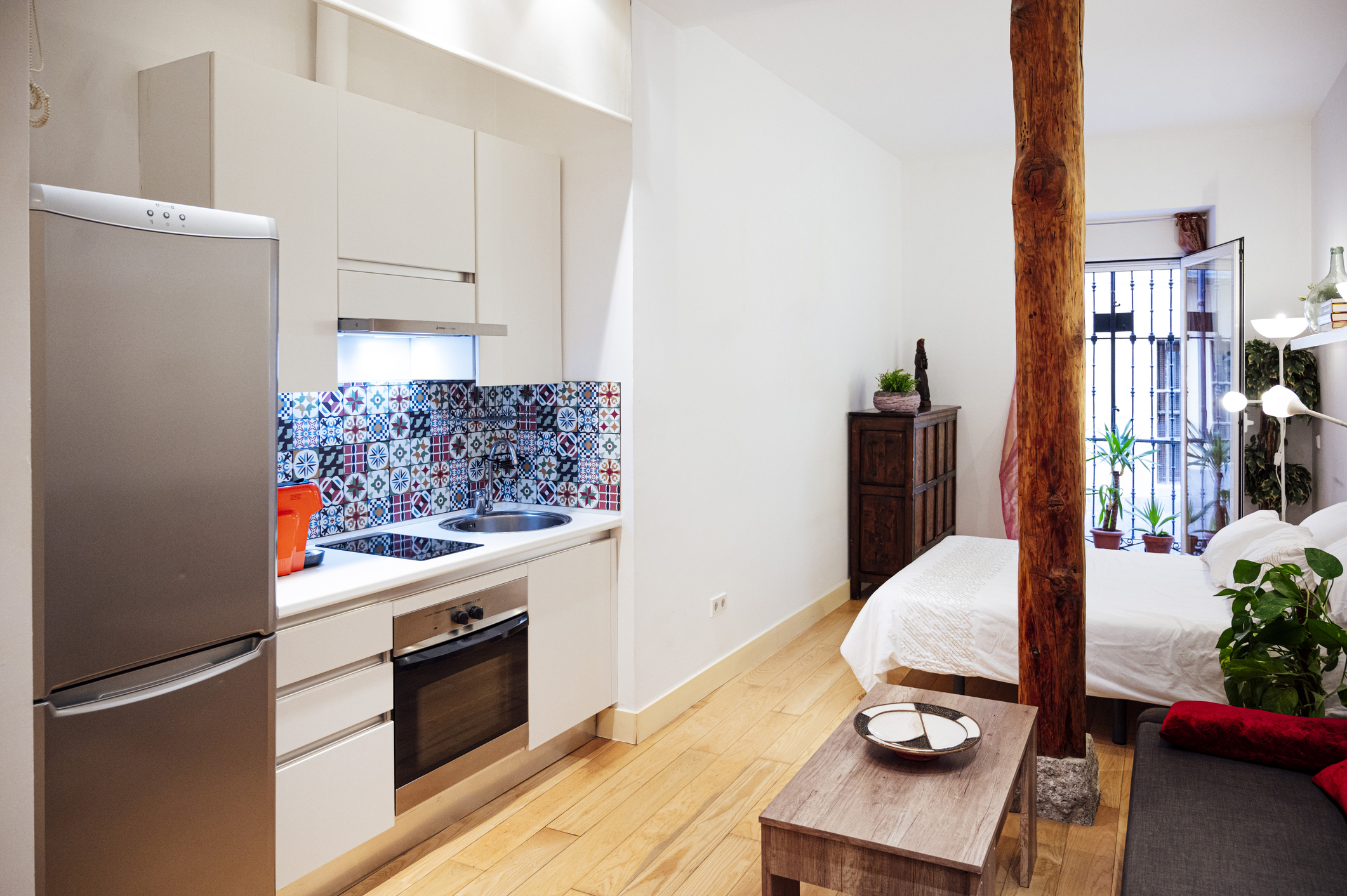 Kitchenette next to a bed in a suite bedroom.