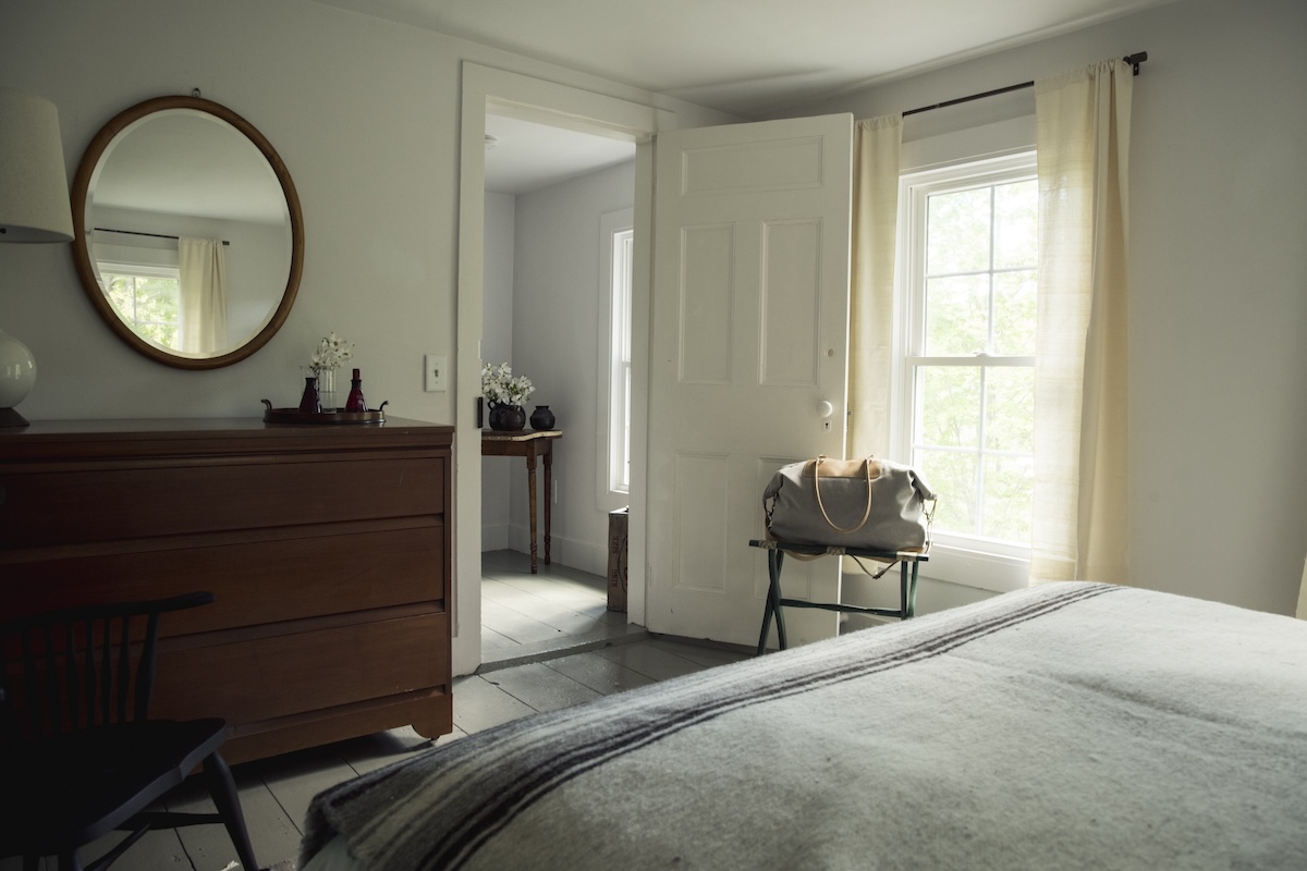 A bright guest room prepared with luggage rack .