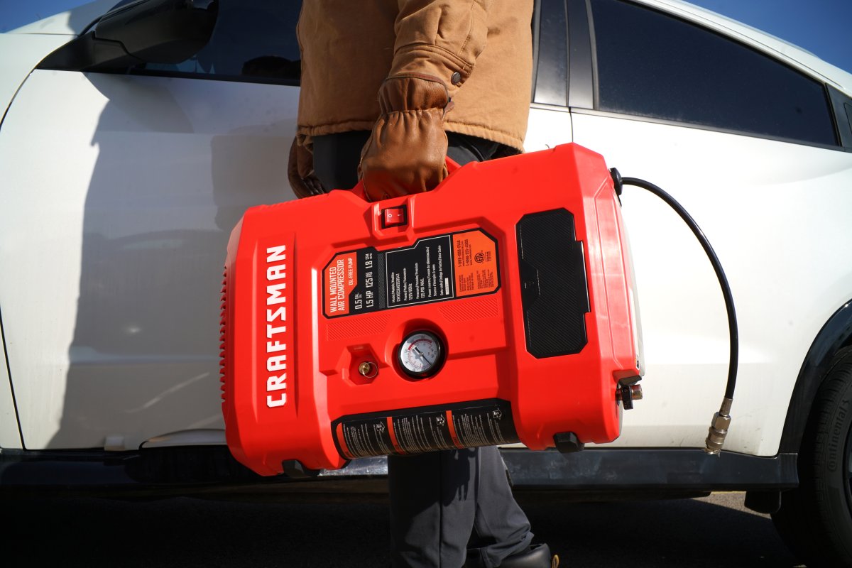 Craftsman Wall-Mountable Portable Air Compressor carried into a garage