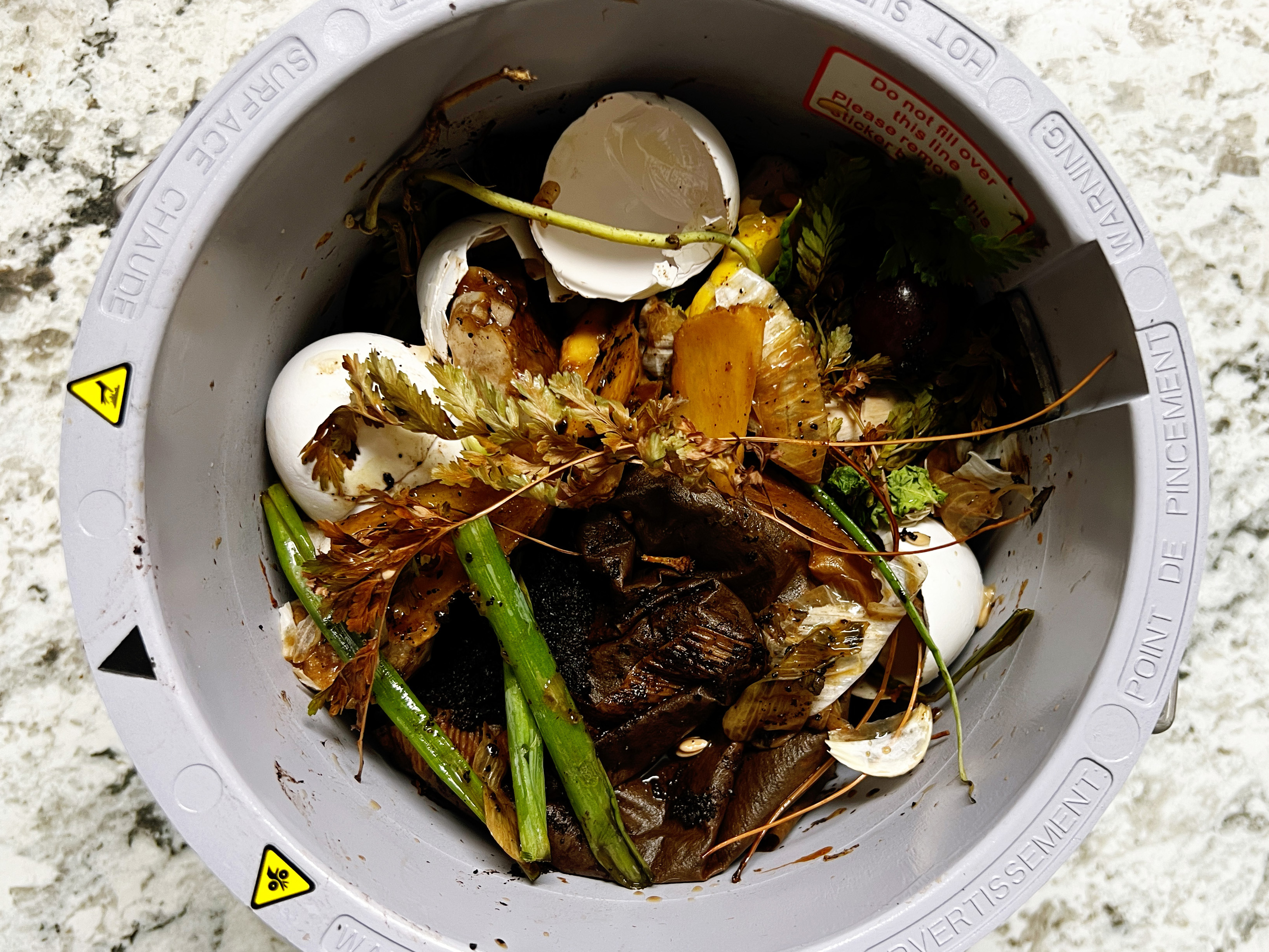 Egg shells, herbs, and other food waste in Vego kitchen composter bin